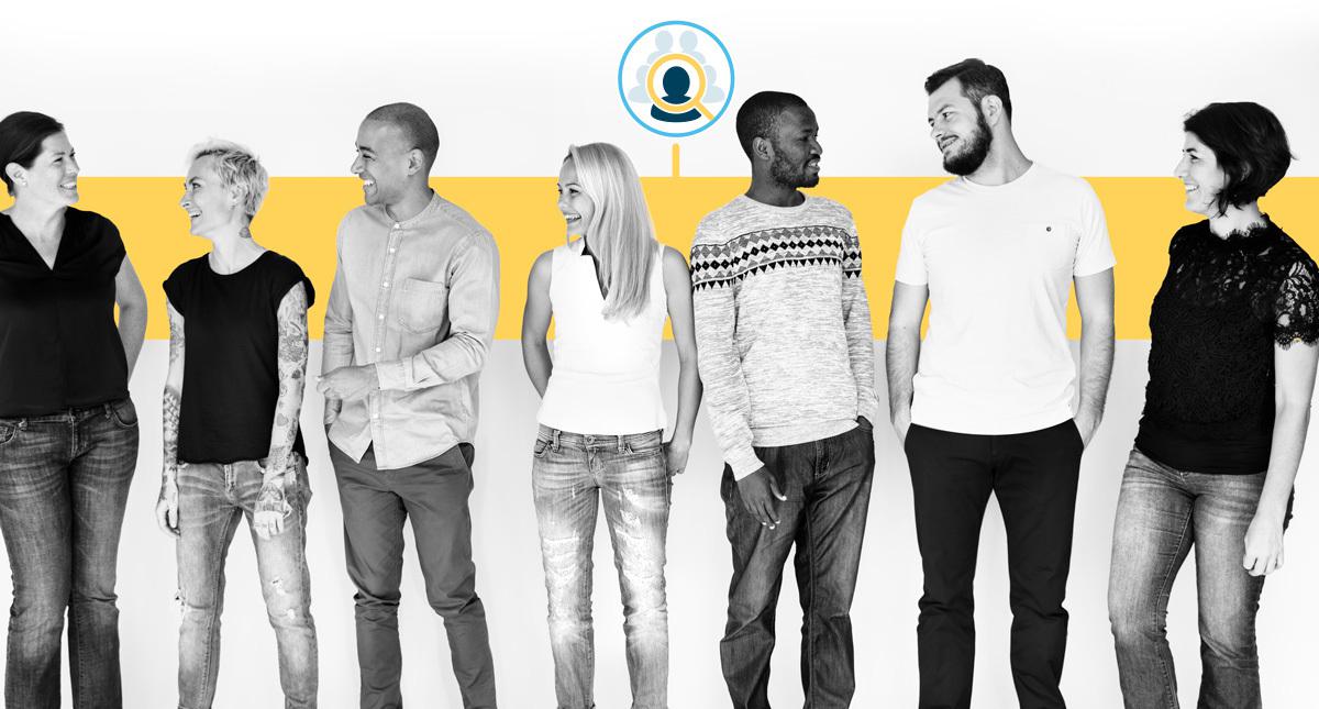 A team of people in casual clothing standing in front of a yellow background.