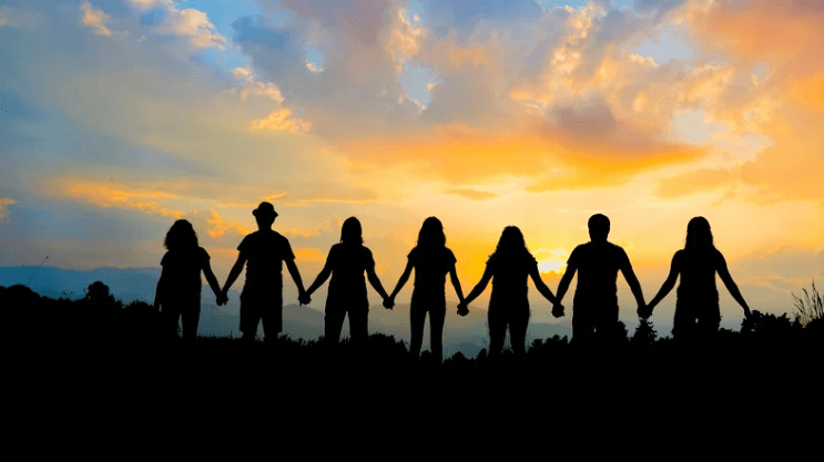 People holding hands at sunset